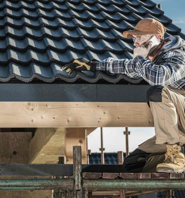 Roof Construction Worker Making Phone Call While Staying on Scaffolding.