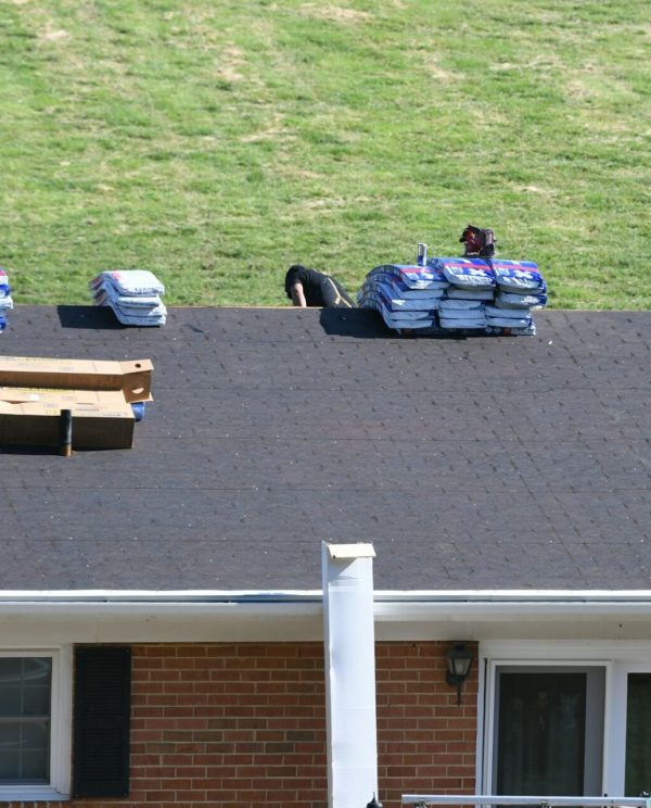 Roofers roofing company repairing a damaged roof with holes, insurance claim storm damage